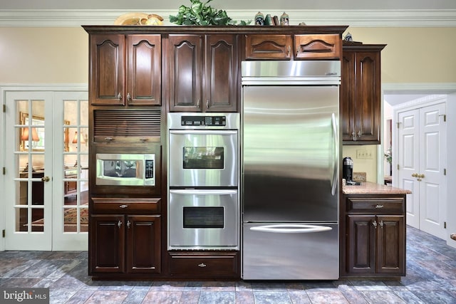 kitchen with built in appliances, ornamental molding, and dark brown cabinetry