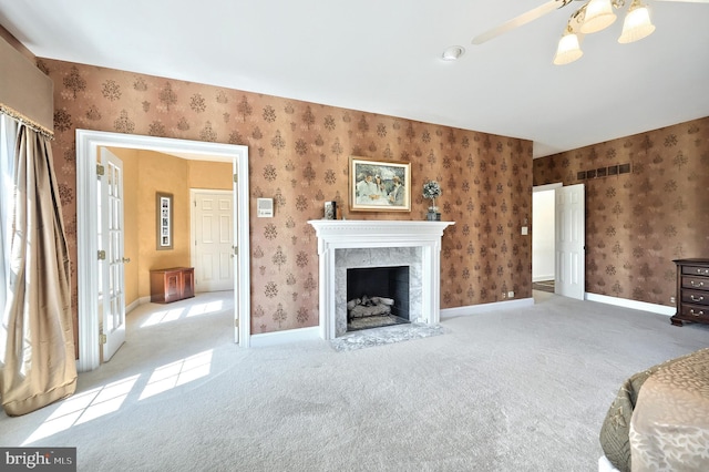 living area featuring a fireplace, visible vents, wallpapered walls, and carpet floors