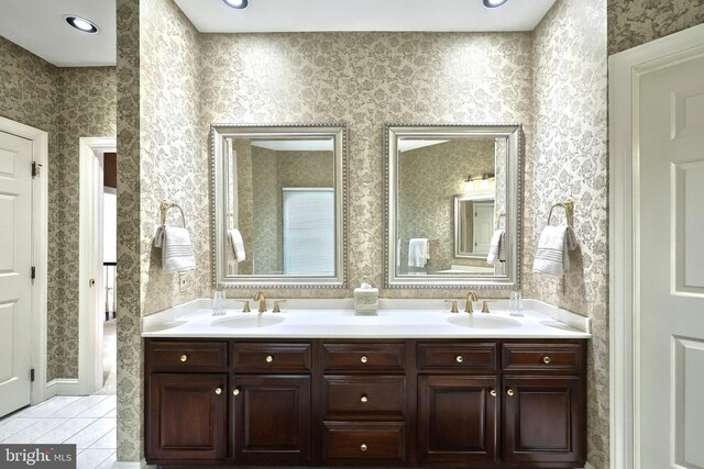 full bathroom with double vanity, a sink, wallpapered walls, and tile patterned floors