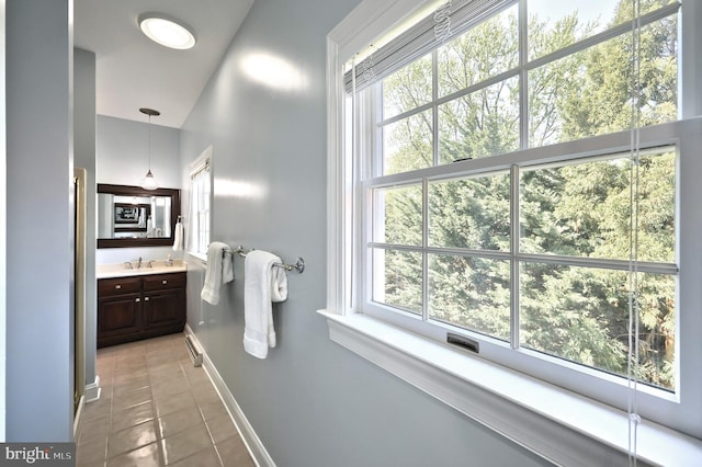 bathroom with tile patterned floors, a healthy amount of sunlight, vanity, and baseboards