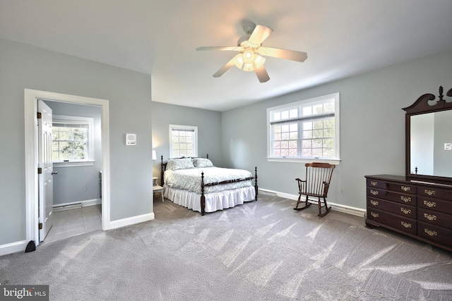 carpeted bedroom featuring multiple windows, ceiling fan, and baseboards