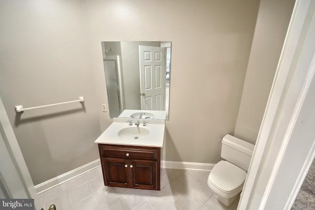 bathroom with toilet, tile patterned flooring, vanity, and baseboards