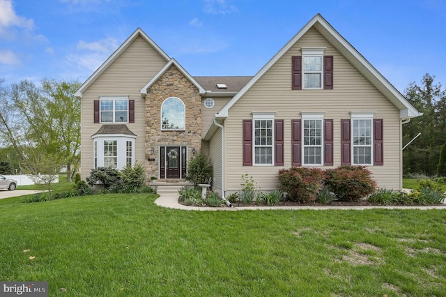 traditional-style house with stone siding and a front yard
