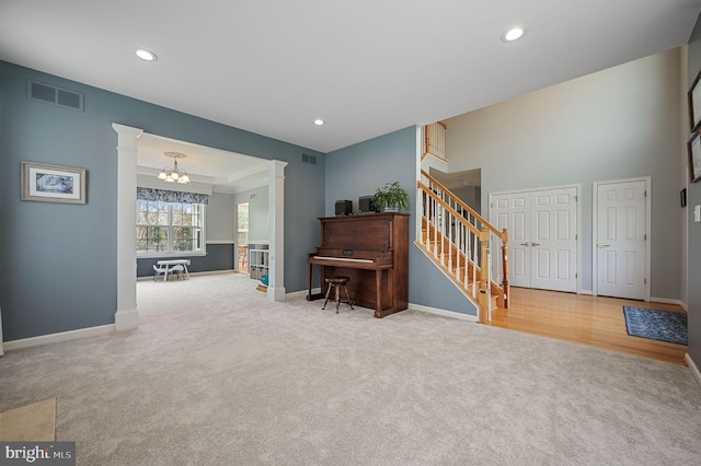 sitting room featuring baseboards, carpet, stairs, and decorative columns
