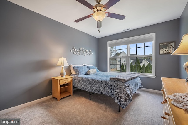 carpeted bedroom with visible vents, a ceiling fan, and baseboards