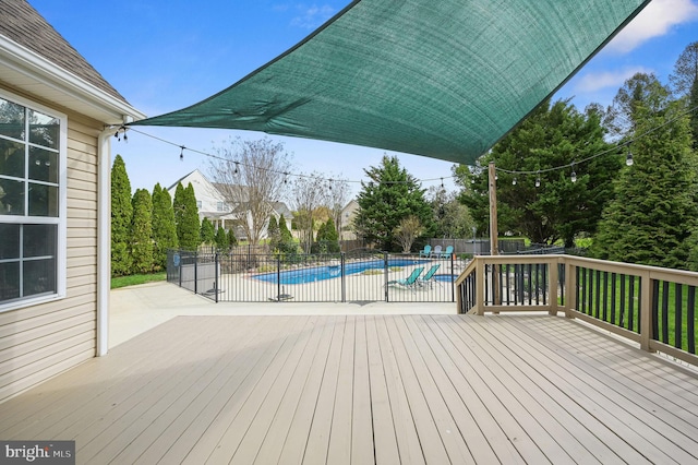 wooden deck with a fenced backyard, a fenced in pool, and a patio