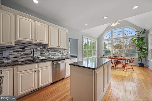 kitchen with dishwasher, light wood finished floors, decorative backsplash, and a sink