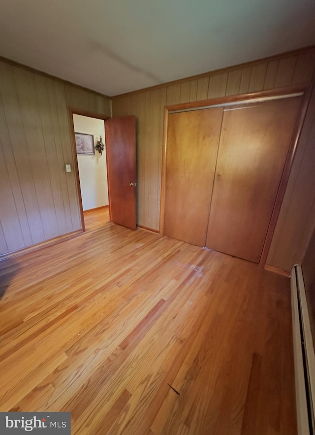 1222 Hoff Rd, Hanover, PA 17331 - unfurnished bedroom featuring wooden walls, a closet, baseboard heating, and wood finished floors