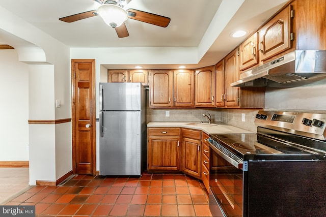 kitchen featuring a sink, decorative backsplash, ceiling fan, stainless steel appliances, and under cabinet range hood