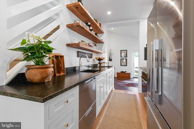 bar with light wood-style flooring, recessed lighting, a sink, vaulted ceiling, and appliances with stainless steel finishes