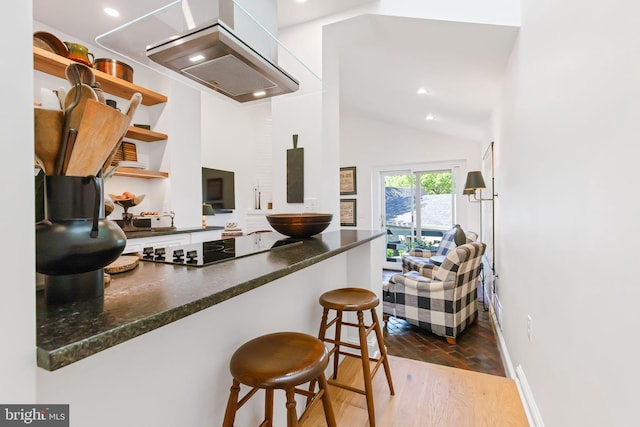 kitchen with lofted ceiling, exhaust hood, black electric stovetop, open shelves, and baseboards