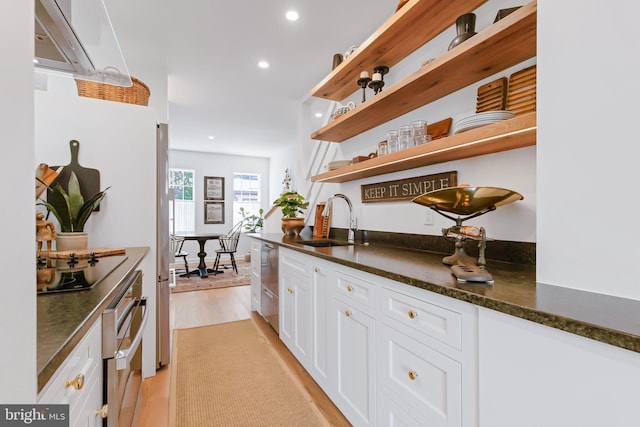 bar featuring recessed lighting, light wood-style floors, appliances with stainless steel finishes, and a sink
