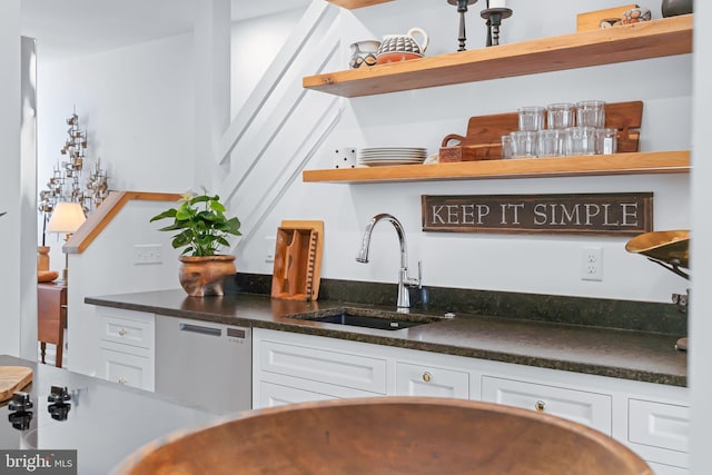 bar with stairs, dishwashing machine, a sink, and indoor wet bar