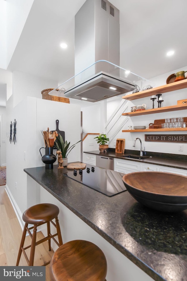 kitchen with a sink, open shelves, island range hood, black electric stovetop, and light wood-type flooring