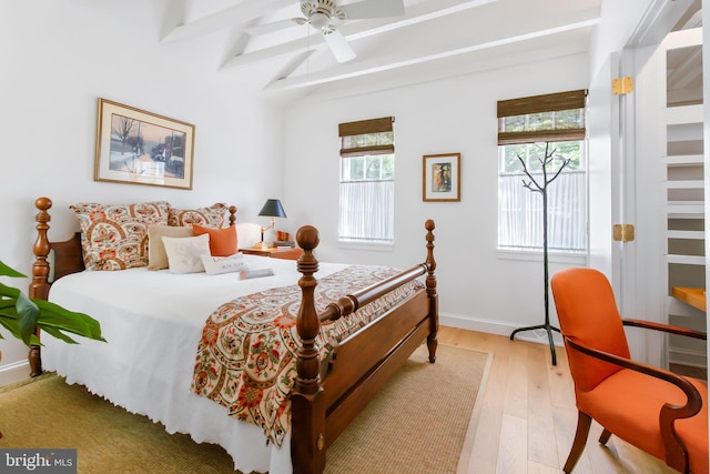 bedroom featuring a ceiling fan, beamed ceiling, light wood-type flooring, and baseboards