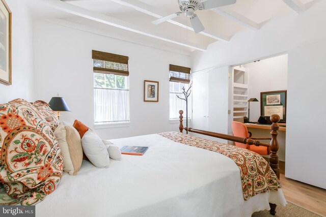 bedroom featuring ceiling fan, beamed ceiling, and wood finished floors
