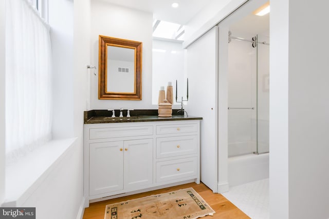 full bathroom featuring vanity, visible vents, and wood finished floors