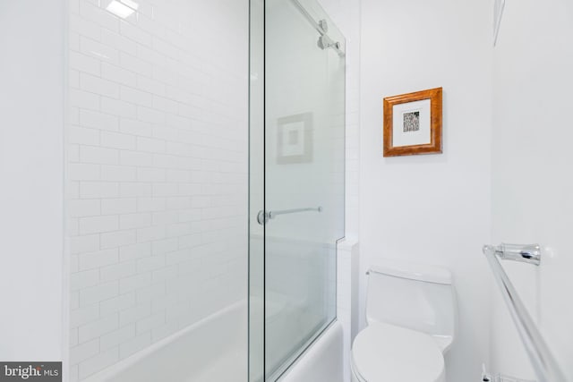 full bath featuring toilet and shower / bath combination with glass door