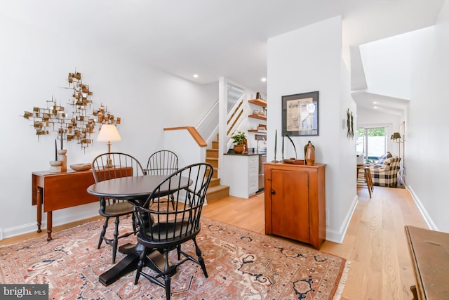 dining area with baseboards, stairs, light wood-style floors, and recessed lighting