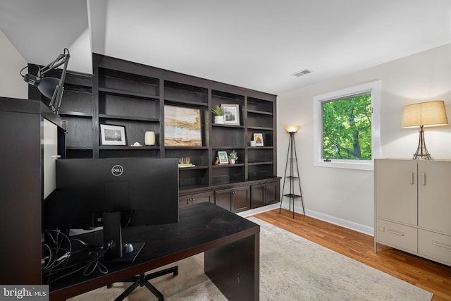 office area featuring visible vents, baseboards, and light wood-type flooring
