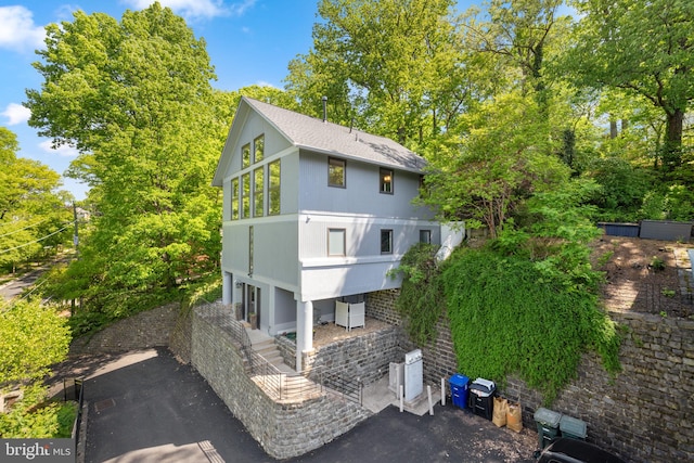 rear view of house featuring a shingled roof