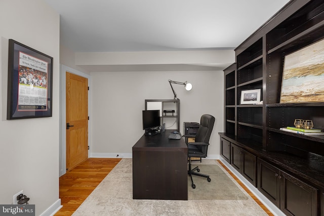 office with baseboards and light wood-style flooring