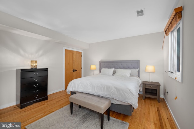 bedroom featuring baseboards, visible vents, and light wood-style floors