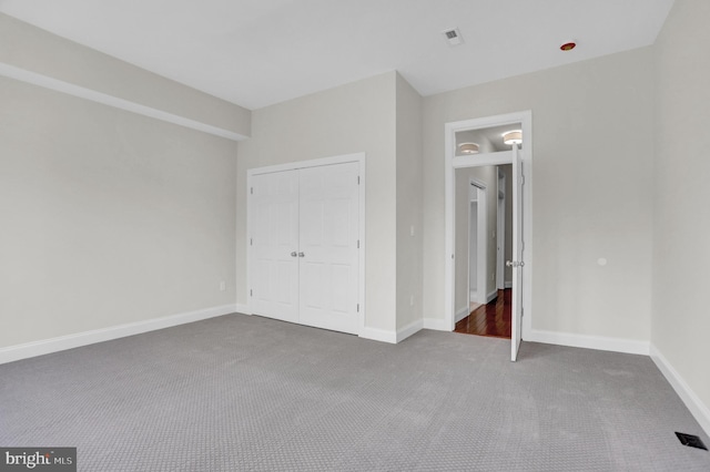 unfurnished bedroom featuring baseboards, visible vents, a closet, and carpet