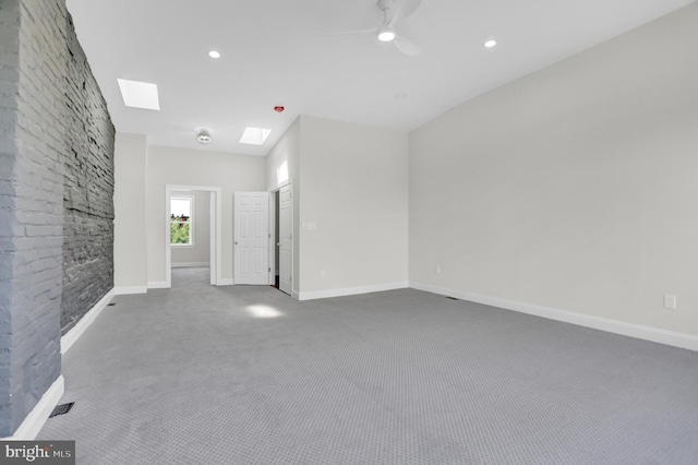 carpeted empty room with a ceiling fan, baseboards, recessed lighting, and a skylight