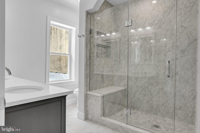 bathroom featuring toilet, a stall shower, marble finish floor, and a wealth of natural light