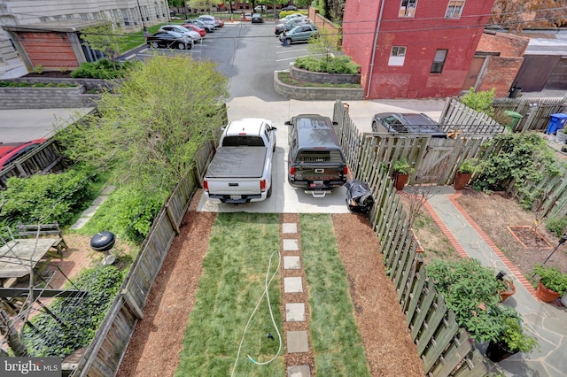 uncovered parking lot featuring fence private yard and a gate