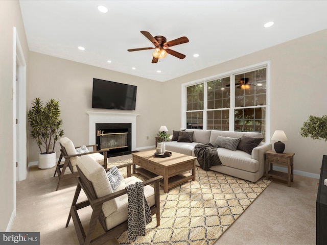 living room featuring a ceiling fan, a fireplace with flush hearth, light carpet, baseboards, and recessed lighting