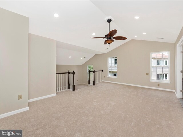 additional living space with baseboards, lofted ceiling, light colored carpet, and ceiling fan
