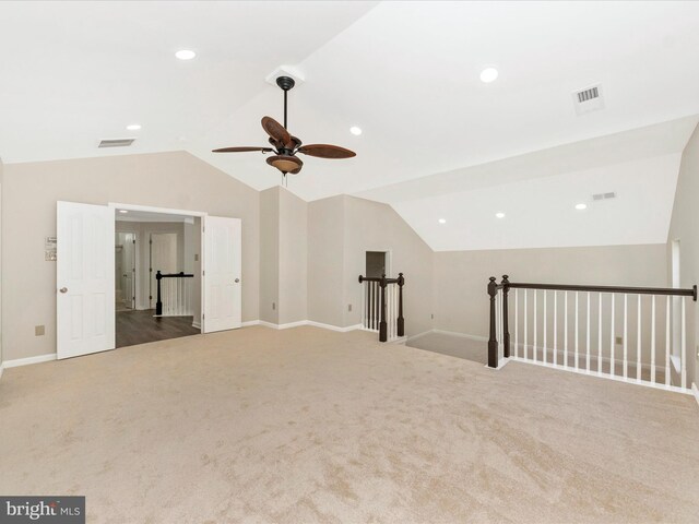 spare room with lofted ceiling, a ceiling fan, visible vents, and carpet