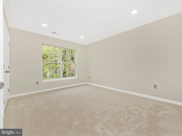 spare room with light carpet, baseboards, visible vents, and recessed lighting