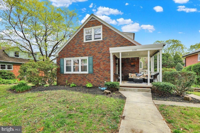 view of front facade featuring an outdoor hangout area, brick siding, and a front lawn