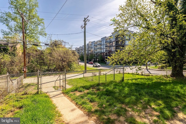 view of home's community featuring a gate, fence, and a lawn
