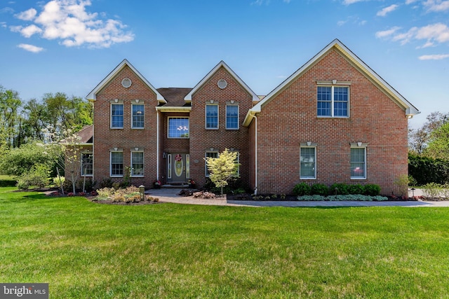 view of front of house featuring brick siding and a front yard