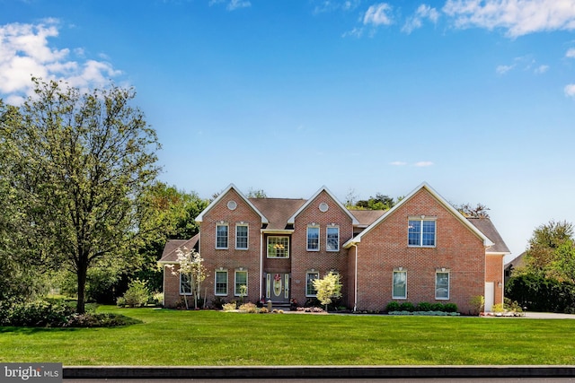 view of front of house featuring brick siding and a front yard