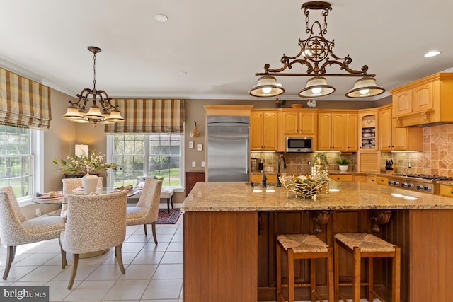 kitchen with a sink, light tile patterned floors, ornamental molding, and stainless steel appliances