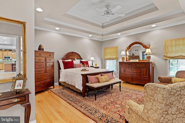 bedroom featuring recessed lighting, ornamental molding, wood finished floors, and a raised ceiling