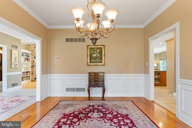 dining area featuring visible vents, ornamental molding, wood finished floors, and a chandelier