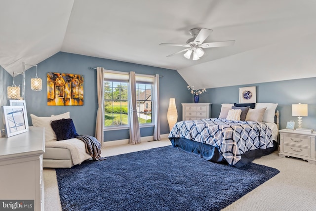 carpeted bedroom with ceiling fan and vaulted ceiling