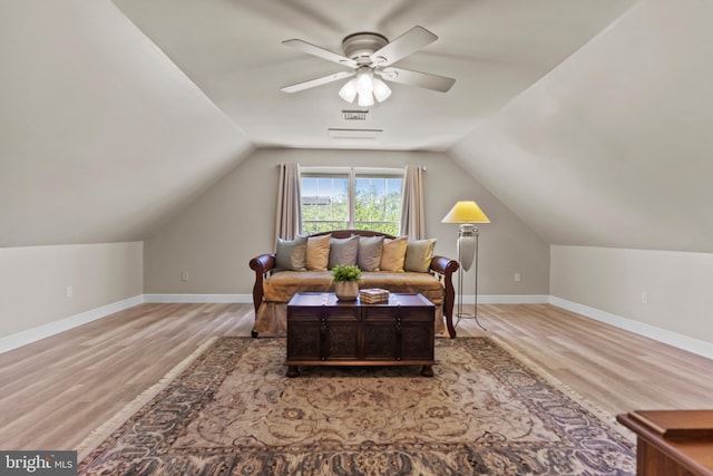 interior space with a ceiling fan, baseboards, wood finished floors, and lofted ceiling