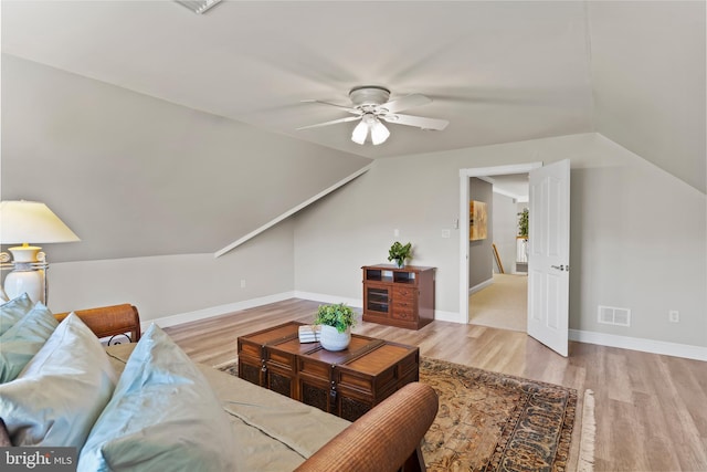 living room featuring visible vents, ceiling fan, wood finished floors, and vaulted ceiling