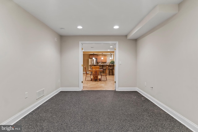carpeted spare room featuring baseboards, recessed lighting, and visible vents