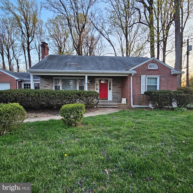 single story home featuring a chimney, a front lawn, and brick siding