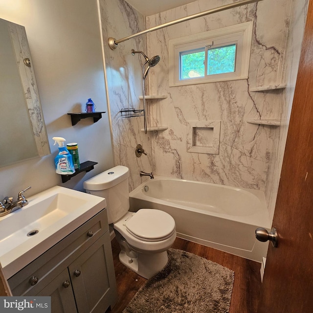 full bath featuring wood finished floors, vanity, shower / bathtub combination, and toilet