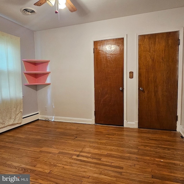 unfurnished room featuring a ceiling fan, hardwood / wood-style flooring, and baseboards