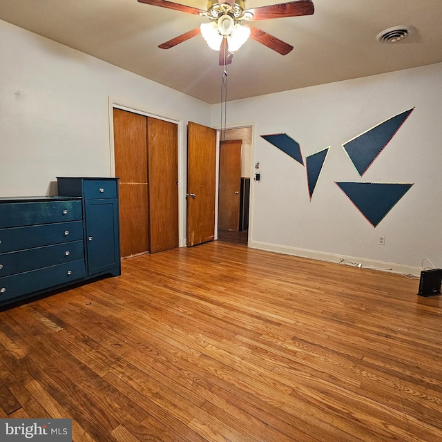 unfurnished bedroom featuring wood finished floors, ceiling fan, and baseboards